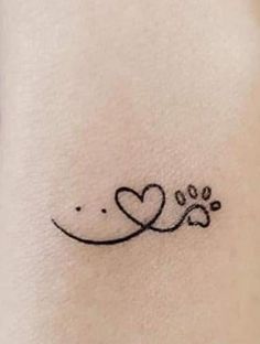 a dog paw and heart tattoo on the ankle