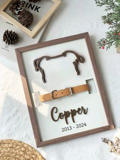 a wooden sign that says copper on it next to some pine cones and other items