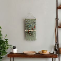 a wooden table topped with two bowls and plates on top of it next to a plant