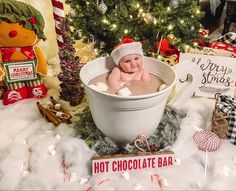 a baby in a bathtub surrounded by christmas decorations and gifts for the holiday season