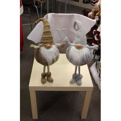 two knitted gnomes sitting on top of a wooden table