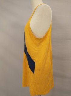 "From the estate of a collegiate crew member this is a 1970's athletic tank top jersey. Could have been for rowing or track, any sport a tank was appropriate for. Color is sunflower yellow - gold with navy blue stripe and lettering. Letters are N 2V, stripe is sewn on. Light/mid weight knit, label missing, likely made in USA. No size marked. Overall condition good, seems to have aged with a very slight diagonal twist. Some light marks on left shoulder and left side back. Has stretch, measurement Sporty Tank Top For College In Summer, Sporty Summer Tank Top For College, Cotton Tank Top For College In Summer, Collegiate Cotton Sports Tank Top, Collegiate Cotton Tank Top For College, Summer Collegiate Top For College, Sporty Cotton Tank Top For College, Collegiate Cotton Sleeveless Tank Top, Collegiate Sleeveless Cotton Tank Top