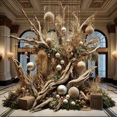 a large christmas tree with ornaments hanging from it's branches in an ornate room