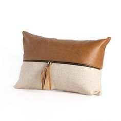 a brown and white pillow with tassels on it