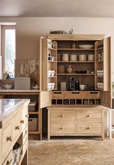 an open cabinet in the middle of a kitchen