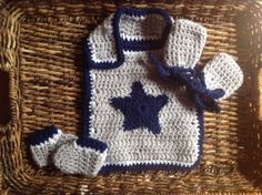 a crocheted baby's outfit and booties on a wicker basket