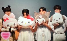 four people are holding stuffed animals in their hands