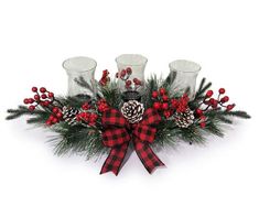 a christmas centerpiece with pine cones, berries and candles