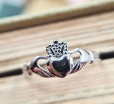 Introducing our exquisite collection of Irish handmade Claddagh rings, where tradition meets craftsmanship in every intricate detail. Each of our rings is a testament to the rich heritage and timeless elegance of the Claddagh symbol, originating from the shores of Galway, IrelandThe iconic Claddagh design, with its hands representing friendship, the crown symbolizing loyalty, and the heart signifying love, is flawlessly rendered in every ring. This timeless symbol serves as a reminder of the end Elegant Engraved Sterling Silver Heart Ring, Elegant Silver Engraved Heart Ring, Nickel-free Heirloom Jewelry For Anniversary, Heirloom Nickel-free Jewelry For Anniversary, Sterling Silver Heirloom Heart Ring For Promise, Heirloom Sterling Silver Heart Ring For Promise, Symbolic Hallmarked Jewelry For Promise Ring, Heirloom Silver Rings With Classic Design, Heirloom Silver Ring With Classic Design