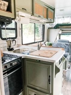 a kitchen area with an oven, stove and sink in a recreational vehicle or trailer