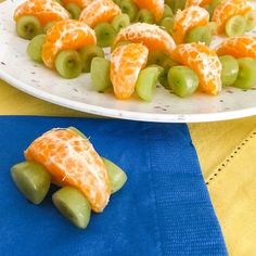 grapes and oranges are arranged on a plate