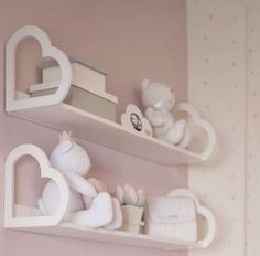 two white shelves with teddy bears and other items on them in a pink girls room