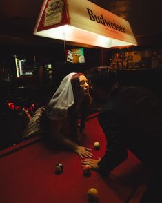 a bride and groom playing pool at budweiser