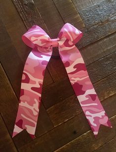 "These pink Camo bows are made with 1 1/2\" Camo printed grosgrain ribbon. They measure approx 4x9 Each bow has a seamless ponytail holder attached. Team orders are always welcome. Great bow for your pink out games" Softball Bow, Cheer Camp, Collegiate Style, Pink Out, Cheer Bows, Ponytail Holder, Pink Camo, Ponytail Holders, Ribbon Slides