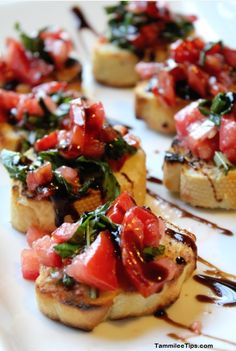 small appetizers with tomatoes and other toppings on a white plate