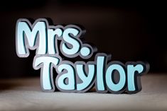 the word mrs taylor is made out of cutout letters and placed on top of each other