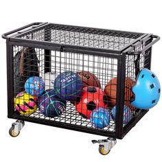 a basket filled with balls and helmets sitting on top of a metal cart, against a white background