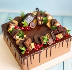 a heart shaped cake with chocolates and berries on top