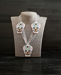 Let me me present you festival style gothic beadwork jewelry set. This sugar skull seed bead earrings and pendant necklace would be great happy Halloween gift set jewelry. The length of the cord is 18.1 (+2) inches. The cord consists of 2 waxed cords of black color, one cord white color and a white ribbon. Pendant high is 2.2 inches, pendant width is 1.8 inches. The length of earrings is 3 inches, the width is 1.8 inches, the length without closure (drop length) is 2.2 inches. You can buy earrings from this set separately by this link https://www.etsy.com/listing/720553398/sugar-skull-helloween-earrings-fesival?ref=shop_home_active_8&frs=1 You can buy pendant necklace from this set separately by this link https://www.etsy.com/listing/721523768/human-sugar-skull-beadwork-art-pendant?ref=sho Bohemian Jewelry For Halloween Gift, Handmade Bohemian Jewelry For Halloween, Handmade Beaded Necklaces For Halloween Gift, White Skull Jewelry For Day Of The Dead, Day Of The Dead Skull Jewelry Gift, Beaded Jewelry For Halloween Festival, Day Of The Dead Multicolor Skull Jewelry, Multicolor Beaded Halloween Jewelry, Multicolor Skull Jewelry For Day Of The Dead