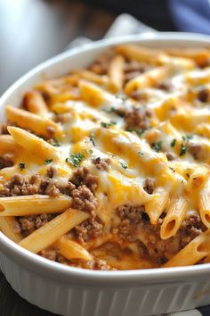 a casserole dish with meat, cheese and sauce in it on a table