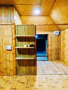 the inside of a bamboo hut with shelves and lights on each side of the room