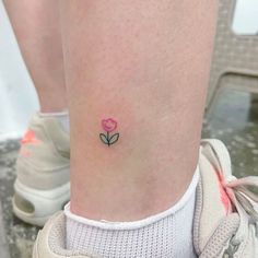 a small pink rose tattoo on the ankle