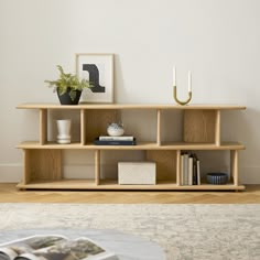 a living room with a book shelf and vases on the table next to it