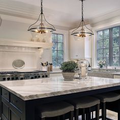 a large kitchen with marble counter tops and an island in front of the stove top