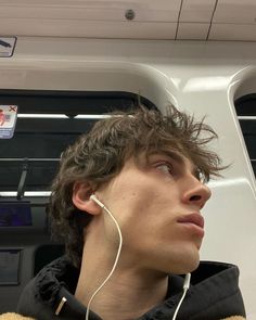 a young man wearing ear buds while riding on a bus