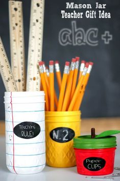 some pencils and markers are sitting in a cup next to a chalkboard with the words mason jar teacher gift idea