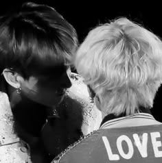 black and white photograph of two women facing each other with love written on their vests