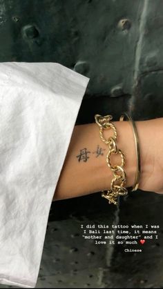 a woman's arm with a tattoo on it and a quote written in chinese