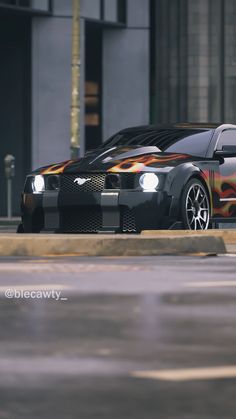 a car with flames painted on it parked in front of a building