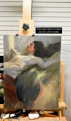 an artist's easel with a painting on it and a quote written in black