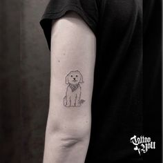 a small dog tattoo on the left arm