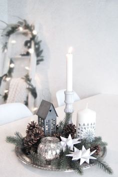 a silver plate topped with pine cones and candles