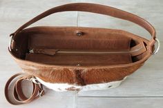 "COWHIDE PURSE, COWHIDE Handbag, Leather Tote Bag. Country Tote Bag in Calf Hair Brown and White Designer Bag, Sling Bag, Zipper Top Bag. This fabulous brown white fur goat leather bag is a serious show stopper. Gorgeous caramel and white cowhide patches on this superb handcrafted leather tote / bucket bag in dazzling brown and white calf fur shoulder bag. Smart additions includes internal pockets for phones and sun glasses plus a free zippered coin purse perfect for lipstick and other small ite White Designer Bag, Cowhide Purse, Cowhide Handbags, Leather Factory, Cowhide Bag, Hair Brown, White Fur, Sling Bags, Goat Leather