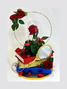 Elevate the elegance of your event decor with our BEAUTY and the BEAST CENTERPIECE. This enchanting centerpiece features a stunning red rose symbolizing love and passion, delicately placed on top of a stack of books. The intricate design also includes a mirror and a glass dome with a beautifully arranged rose inside. Perfect for Quinceanera, Sweet Sixteen or a fairytale-themed wedding, this centerpiece will add a touch of romance and whimsy to your special day. Make a statement with our BEAUTY a Beauty And The Beast Centerpiece Ideas, Beauty And The Beast Table Decorations, Beauty And The Beast Centerpiece, Rapunzel Centerpiece Ideas, Beauty And The Beast Wedding, Beauty And The Beast Quinceanera, Royal Theme Party, Beauty And The Beast Quince, Beauty And The Beast Diy