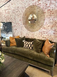 a living room filled with furniture and a brick wall