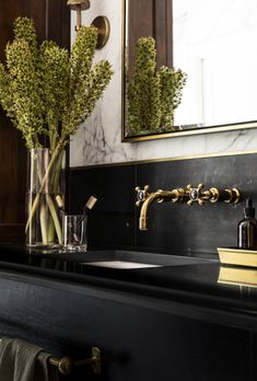 a bathroom sink with two vases on top of it