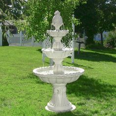 a water fountain sitting on top of a lush green field