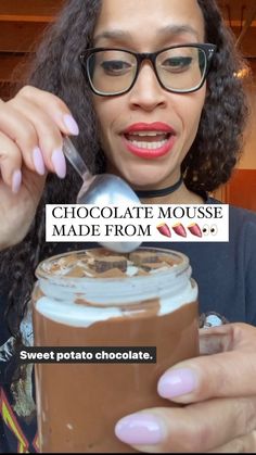 a woman holding a spoon in front of a chocolate mousse