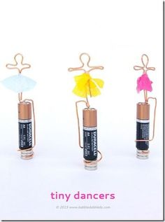 three tiny batteries with colorful paper angel decorations on them