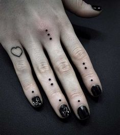 a woman's hand with black and white designs on her fingers, which are dotted with hearts