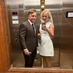 a man and woman taking a selfie in an elevator