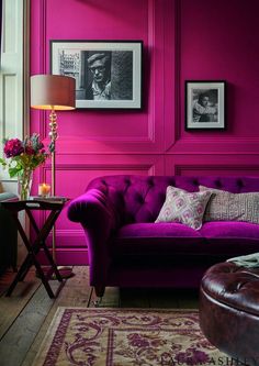 a living room with pink walls and furniture