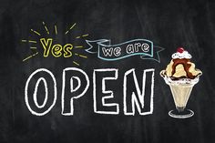 an ice cream sundae with the words yes we are open written in chalk on a blackboard