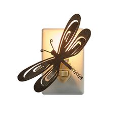 a light that is on top of a wall with a dragonfly design on it