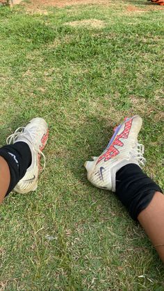 a person's legs and shoes in the grass