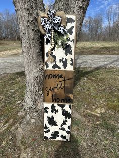 a wooden sign that says home sweet mom next to a tree